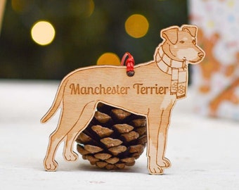 Puede incluir: Un adorno navideño de madera con forma de perro Manchester Terrier con una bufanda. El adorno está grabado con las palabras "Manchester Terrier".