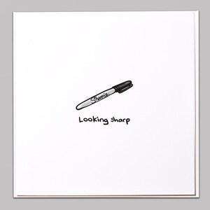 Peut inclure: Une carte blanche avec un marqueur noir Sharpie dessiné dessus. Le texte "Looking sharp" est écrit sous le marqueur.