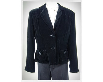May include: A black velvet blazer with a fitted silhouette and three buttons. The blazer has a small pocket on each side and a pleated detail on the front.