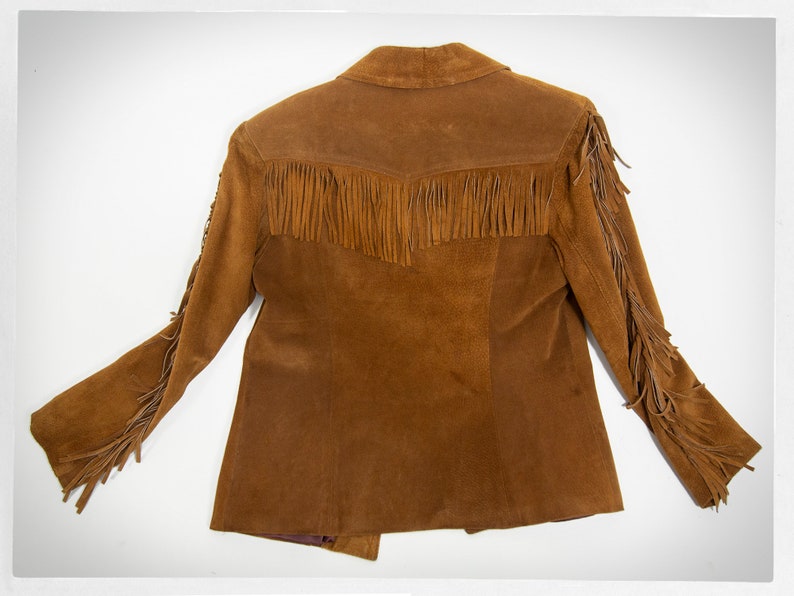 May include: A brown suede jacket with fringe detailing on the sleeves and bottom hem.