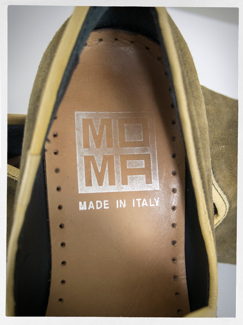 Puede incluir: Primer plano del interior de un zapato de ante marr&oacute;n con forro de cuero beige. El zapato tiene una etiqueta que dice "MOMH MADE IN ITALY".