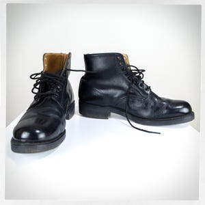 May include: A pair of black leather lace-up boots with a rounded toe and a thick sole.