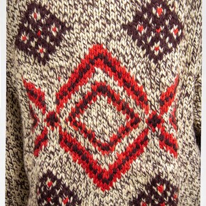 May include: A brown and beige knitted sweater with a red and brown geometric pattern.