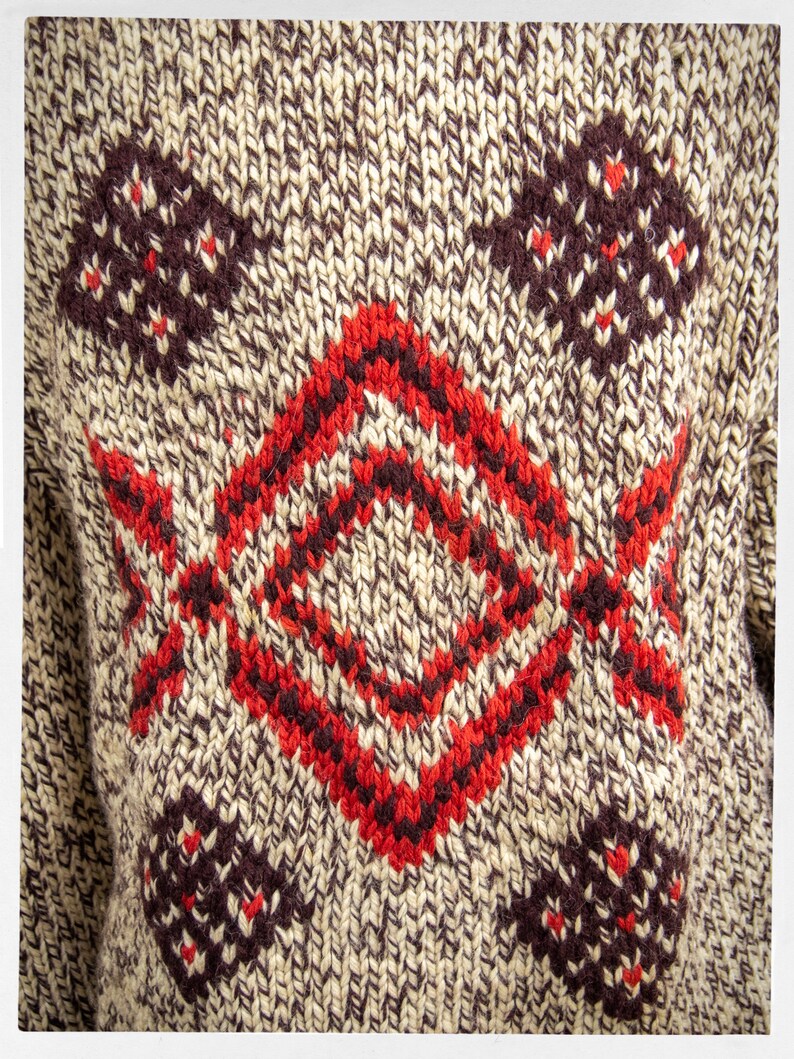 May include: A brown and beige knitted sweater with a red and brown geometric pattern.