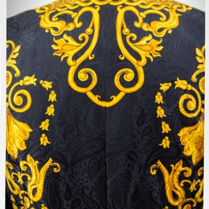 Puede incluir: Blazer negro con un patr&oacute;n de cachemira dorado. El patr&oacute;n presenta intrincados dise&ntilde;os florales y remolinos.