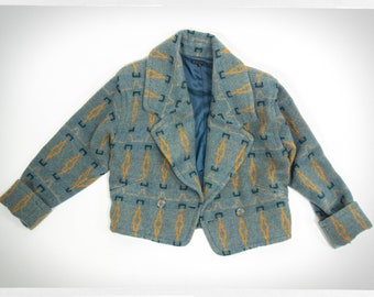 Puede incluir: Una chaqueta corta de color azul y dorado con un diseño estampado, cierre de doble botonadura y cuello.