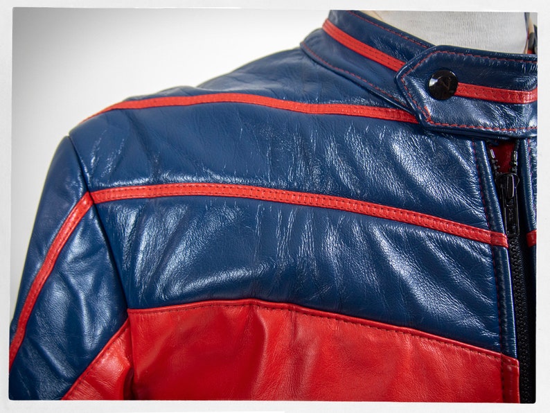 May include: A blue and red leather jacket with red stitching. The jacket has a zipper closure and a stand-up collar.