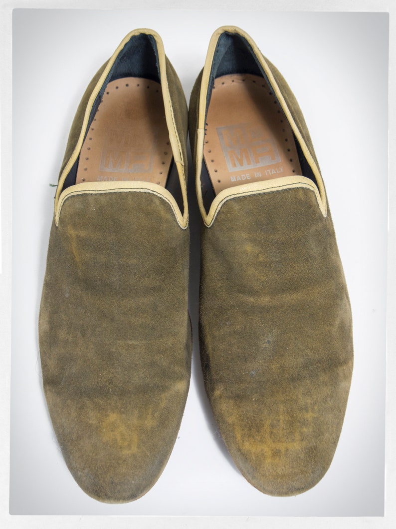 Puede incluir: Un par de zapatillas de ante marr&oacute;n con un ribete marr&oacute;n claro alrededor de la parte superior. Las zapatillas tienen el texto "MADE IN ITALY" en el interior.