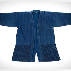 May include: A dark blue indigo Japanese-style jacket with a quilted diamond pattern on the bottom. The jacket is open and has a long, flowing design.