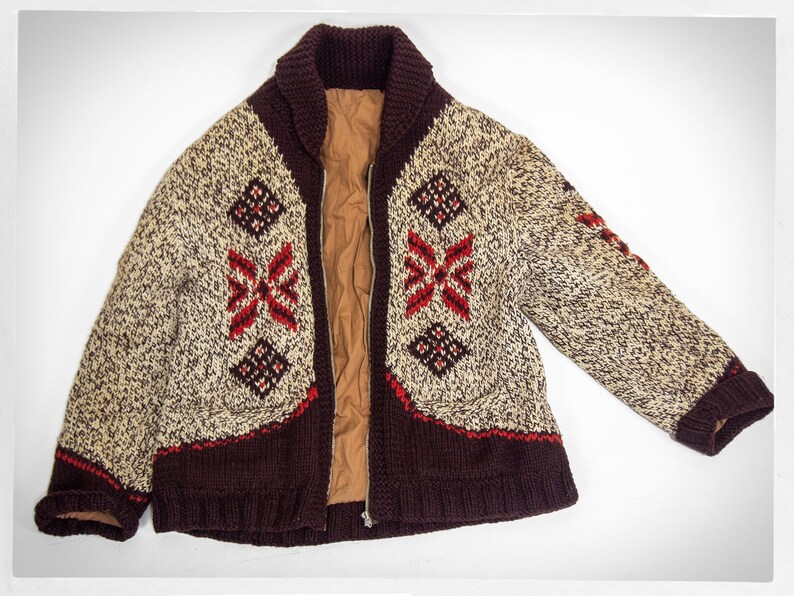 May include: A brown, beige, and red knitted cardigan with a zipper closure and a geometric pattern. The cardigan has a collar and long sleeves.