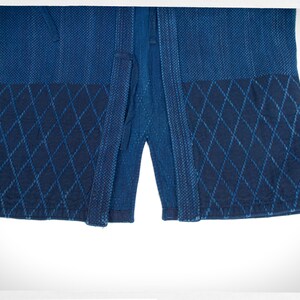 May include: A blue indigo cotton kimono with a diamond pattern on the bottom hem.