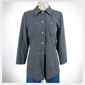 May include: A gray button-down jacket with long sleeves, a collar, and four front pockets. The jacket has silver buttons and a tailored fit. The jacket is displayed on a mannequin with a patterned scarf at the neck.