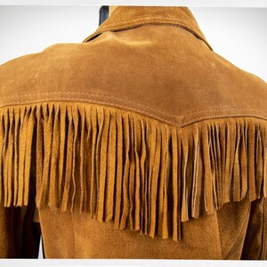 May include: Brown suede jacket with fringe detail on the back and sleeves.