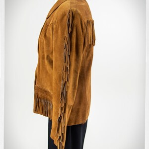 May include: A brown suede jacket with fringe detailing on the sleeves and hem.