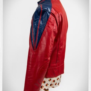 May include: A red leather jacket with blue leather panels on the shoulders and sleeves. The jacket has a stand-up collar and a zipper closure.
