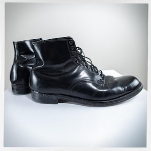 May include: A pair of black leather lace-up boots with a rounded toe and a thick sole.