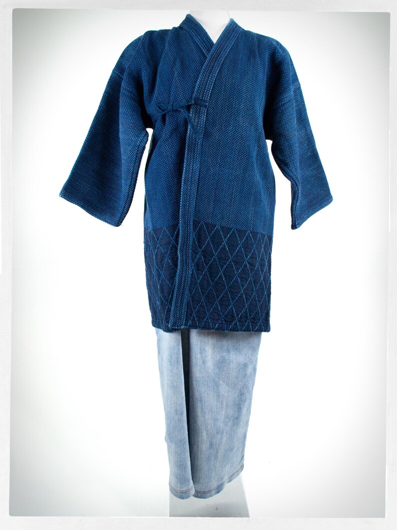 May include: A blue cotton kimono with a diamond pattern on the bottom. The kimono is tied at the waist and has long sleeves.