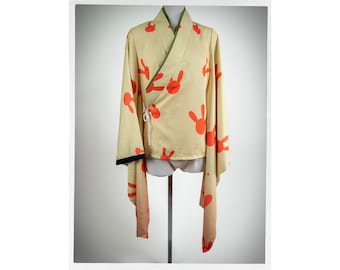 May include: A light yellow kimono with a green trim and orange bunny print.