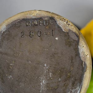 Peut inclure: Le fond d'un vase en c&eacute;ramique brun avec le texte "RAVELLO 280-1" estampill&eacute; au fond.