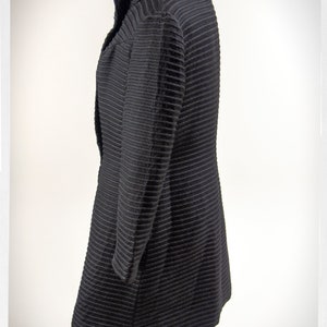 May include: A black ribbed long-sleeved jacket with a high collar.
