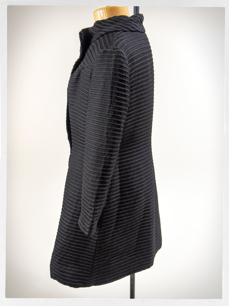 May include: A black ribbed long-sleeved jacket with a high collar.