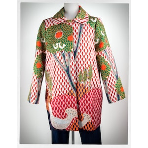 May include: A long-sleeved coat with a colourful, patterned design featuring trees, birds, and geometric shapes. The coat has a white background with red, green, orange, and blue accents.