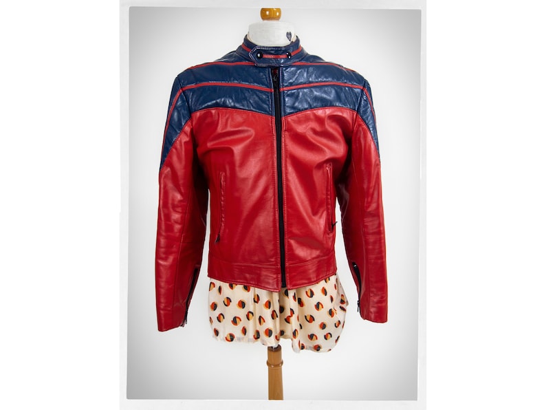 May include: A red leather jacket with blue leather accents. The jacket has a zipper closure and a stand-up collar.