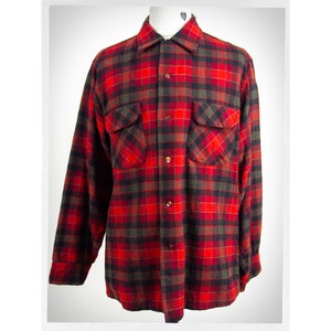 Peut inclure: Une chemise en flanelle à carreaux rouge et noir à manches longues et deux poches poitrine.