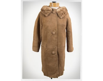 Peut inclure: Un long manteau en daim marron avec un col en fourrure. Le manteau a une fermeture à boutons et deux poches.