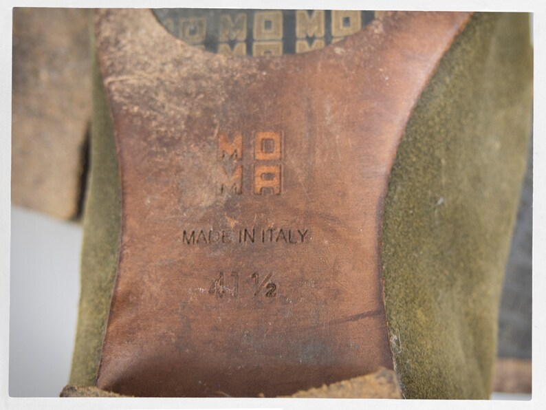 Puede incluir: Primer plano de la suela de un zapato de ante verde con suela de cuero marr&oacute;n. La suela est&aacute; estampada con el texto "Made in Italy" y la talla "41 1/2".