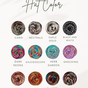 Op de afbeelding: Afbeelding met een kleurenkaart voor garen, getiteld "Hat Color". De kaart toont twaalf bollen garen in verschillende kleuren, waaronder Camo, Neutrals, Eagle Gold, Black and White, Dark Neons, Kaleidoscope, Herb Garden, Shocking, Jazzed, Autumn, Dakota en Songbird.