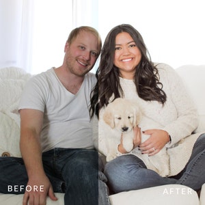 May include: A couple poses on a white couch with a golden retriever puppy. The woman is wearing a white sweater and jeans, and the man is wearing a white t-shirt and jeans. The puppy is sitting on the woman's lap.