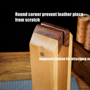 May include: Wooden leathercraft tool with a magnetic button for attaching needles. The tool has round corners to prevent scratching leather pieces. The text on the image says "Round corner prevent leather piece from scratch" and "magnetic button for attaching needle".