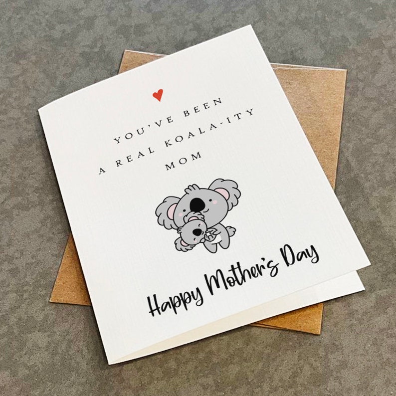 May include: A white card with a red heart and the text "You've been a real koala-ity mom" and a cartoon image of two koalas hugging. The text "Happy Mother's Day" is at the bottom of the card.