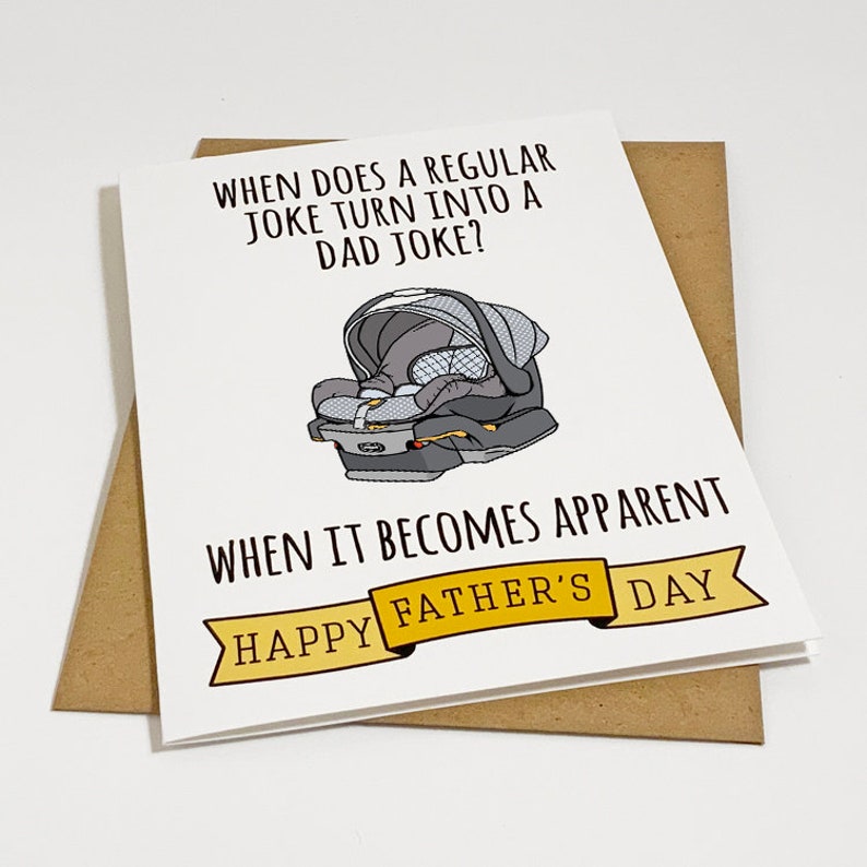 May include: A white card with a black and white illustration of a baby car seat. The text on the card reads "When does a regular joke turn into a dad joke? When it becomes apparent. Happy Father's Day."