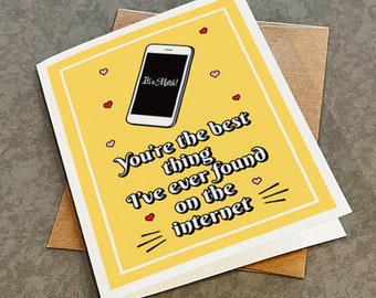 May include: A yellow card with a white border and a black and white illustration of a smartphone with the text "It's a Match!" on the screen. The card has the text "You're the best thing I've ever found on the internet" in black text with pink hearts.