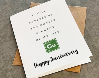 May include: A white greeting card with black text that reads, YOU'LL FOREVER BE THE CUTEST ELEMENT OF MY LIFE. Below the text is a green square containing the chemical symbol Cu for copper, followed by the black script text, Happy Anniversary.