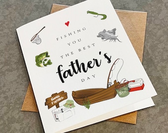 May include: A white card with a red heart and the text "Fishing you the best father's day". The card features illustrations of fishing gear, including a boat, a fishing rod, a net, a tackle box, a bucket of bait, a fish, and a lure.