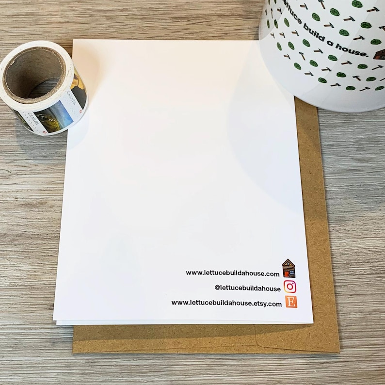 May include: A white card with the text "www.lettucebuildahouse.com", "@lettucebuildahouse", and "www.lettucebuildahouse.etsy.com" printed on it. The card is sitting on a brown envelope.
