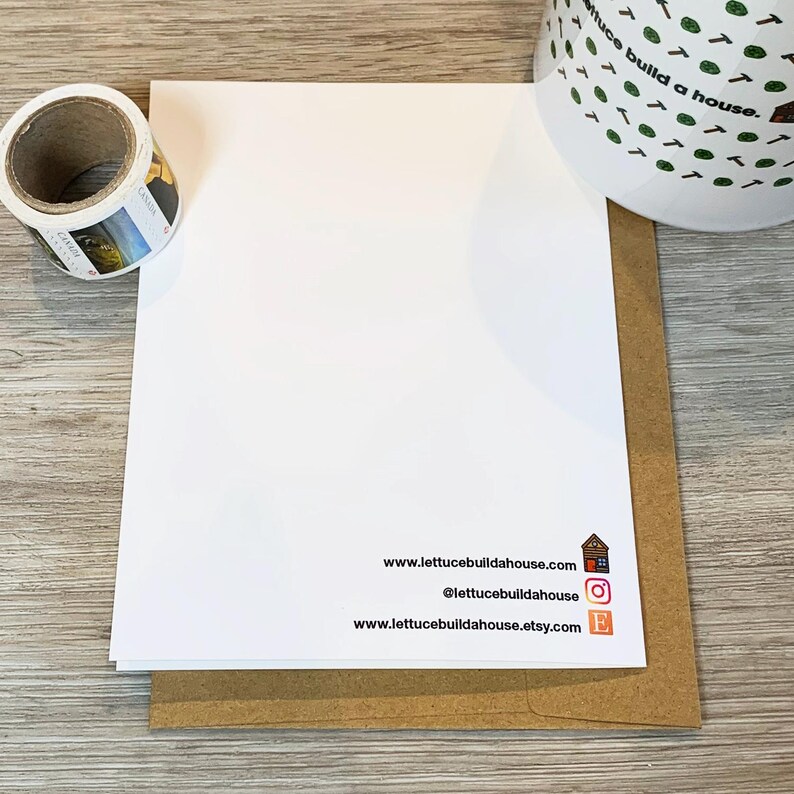 May include: A white card with the text "www.lettucebuildahouse.com", "@lettucebuildahouse", and "www.lettucebuildahouse.etsy.com" printed on it. The card is sitting on a brown envelope.