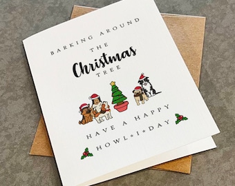 May include: A Christmas card with a white background and a festive message that reads "Barking around the Christmas tree. Have a happy howl-iday". The card features a cartoon illustration of three dogs wearing Santa hats and a Christmas tree.