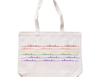May include: A white canvas tote bag with the word "Alameda" repeated multiple times in rainbow colours.