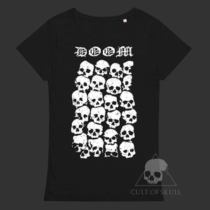 K&ouml;nnte beinhalten: Schwarzes T-Shirt mit einem wei&szlig;en Totenkopf-Motiv und dem Text "DOOM" in gotischer Schrift. Das Totenkopf-Motiv besteht aus vielen kleineren Totenk&ouml;pfen. Der Text "CULT OF SKULL" ist in Wei&szlig; am unteren Rand des T-Shirts aufgedruckt.