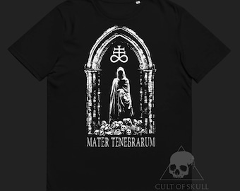 May include: Black t-shirt with a white graphic of a hooded figure standing in a gothic archway with a skull and crossbones symbol above. The text "Mater Tenebrarum" is below the figure. The bottom of the shirt has the text "Cult of Skull".