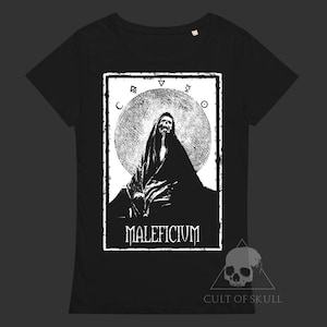 Könnte beinhalten: Schwarzes T-Shirt mit einem weißen Grafikdruck einer Kapuzenfigur vor einem Mond mit Symbolen drumherum. Der Text "MALIFICIVM" befindet sich unterhalb der Figur. Am unteren Rand des Shirts steht der Text "CULT OF SKULL" in weiß.