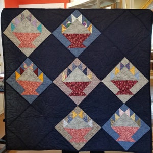 Navy and multi color Throw Size Quilt. Basket design size 48&quot; by 48&quot; with vine and leaf quilting. Machine Washable