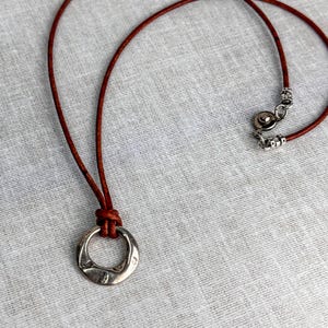 Collar con colgante de cordón de cuero: pieza central moderna de plata martillada, joyería artesanal personalizada.