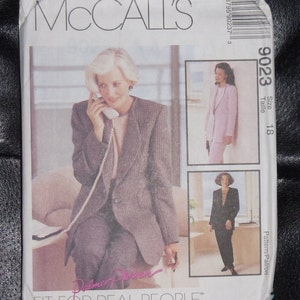 Könnte beinhalten: Ein McCall's Schnittmuster für einen Blazer und eine Hose. Die Schnittmuster-Nummer ist 9023 und die Größe ist 18. Das Schnittmuster ist für "Fit for Real People" und "Fashion for Everybody".