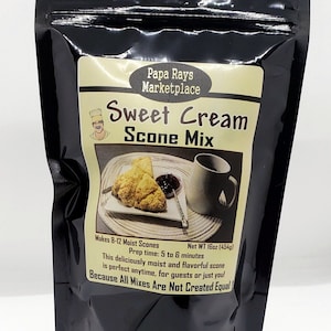 May include: Black pouch of Papa Rays Marketplace Sweet Cream Scone Mix. The label shows a picture of scones with jam and a mug. The package makes 8-12 scones and weighs 16oz (454g).
