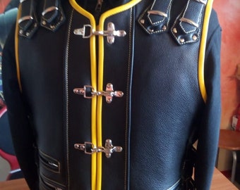 May include: Black leather vest with yellow trim and silver buckles. The vest has multiple pockets and a zip closure.